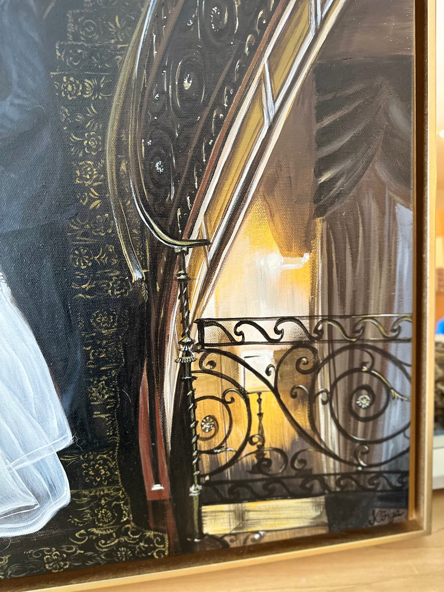 Lower stair detail — wrought-iron scrollwork against the warm tungsten interior light